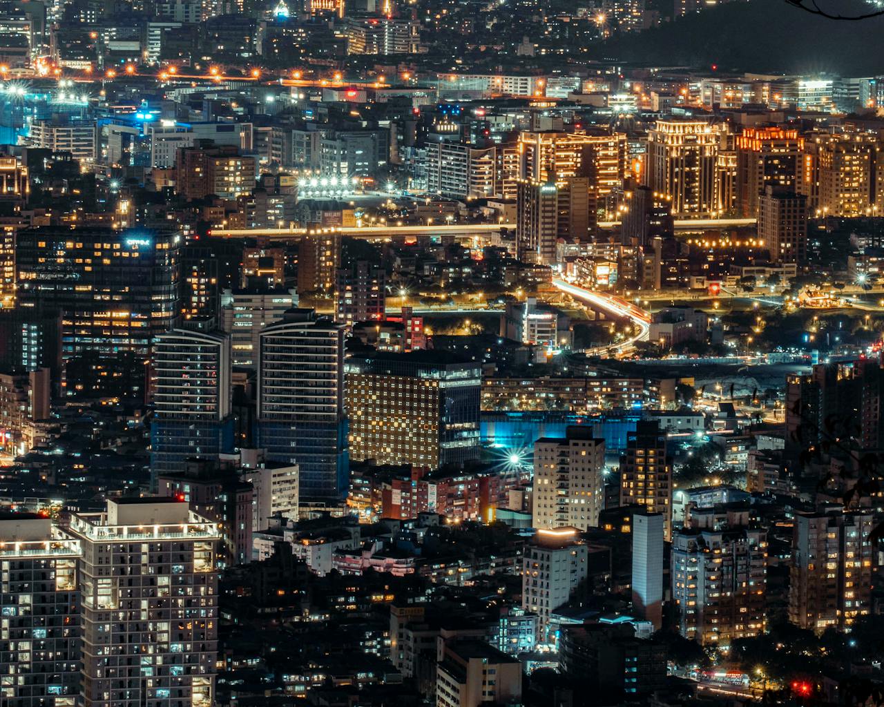 Stunning cityscape showcasing modern architecture illuminated at night from a high vantage point.