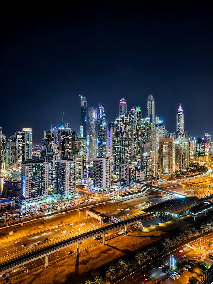 Captivating nighttime aerial of Dubai Marina's iconic skyline, showcasing vibrant city lights and modern architecture.