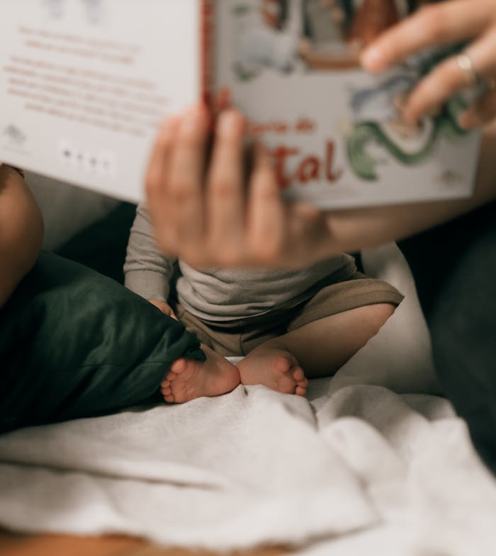 A mother reads a storybook to her toddler indoors, showcasing family bonding and learning.